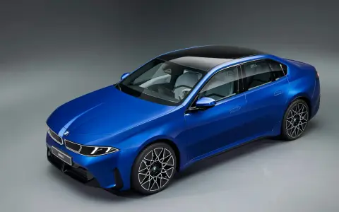 Blauer BMW i3 Neue Klasse Limousine mit schwarzem Dach und futuristischen Felgen.