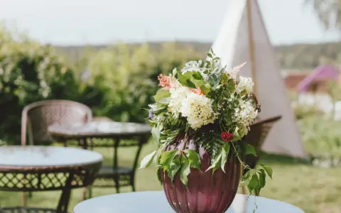Un hermoso arreglo de flores en un jarrón morado, perfecto para celebrar un feliz día del Carmen.