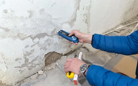Feuchtemessung an einer Wand. Die isotec kosten pro qm hängen vom Ausmaß des Schadens ab.