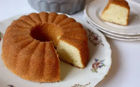 En gyllene sockerkaka i en vacker sockerkaka form, med en bit uppskuren. En klassiker som doftar hembakat.