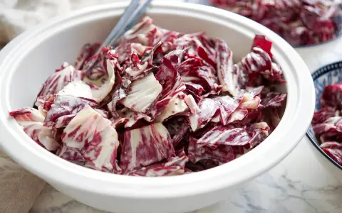 Ein cremiger Radicchio Salat in einer weißen Schüssel, bereit zum Servieren.