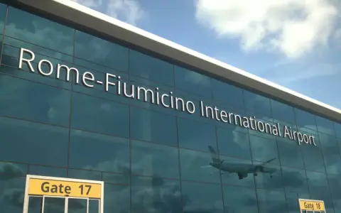 Fasada lotniska Rome-Fiumicino International Airport z napisem i odbiciem samolotu.