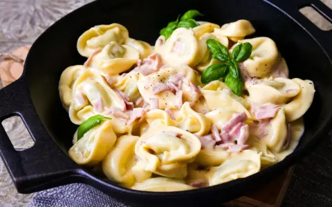 Köstliche Tortellini in cremiger Sauce mit Schinken und frischem Basilikum. Ein einfaches Gericht, das zu den beliebtesten Tortellini Rezepten zählt.