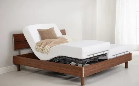 Lit électrique avec matelas mémoire de forme, réglable pour un confort optimal. Un plaid douillet et un coussin invitent à la détente.