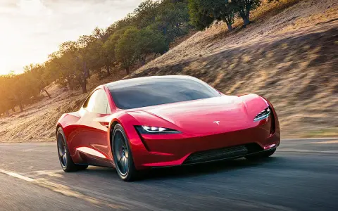 Roter Tesla Roadster rast auf einer Straße, die Beschleunigung von 0 auf 100 km/h ist atemberaubend.