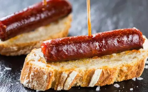Pinchos de chorizo, un clásico de la comida típica de Navarra, servidos sobre pan rústico.