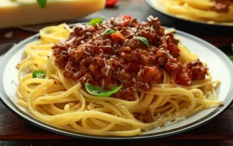 Pyszne spaghetti bolognese z mielonym mięsem, pomidorami i bazylią. Idealne przyprawy do spaghetti podkreślają smak dania.
