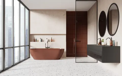 Salle de bain moderne avec baignoire rouille, douche en briques rouges et lavabo suspendu. Le sol en terrazzo offre une belle dimension carrelage.