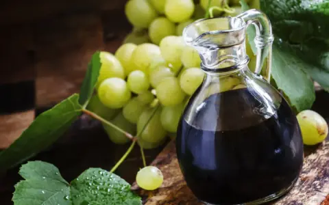 Ciemny płyn w karafce i winogrona. Szukasz, czym zastąpić ocet balsamiczny? Oto inspiracja.