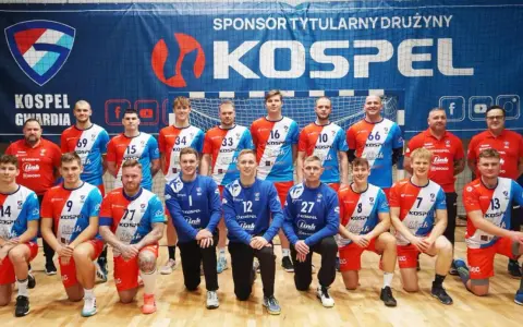 Drużyna Gwardia Koszalin piłka ręczna pozuje do zdjęcia. Zawodnicy w strojach sportowych z numerami na koszulkach.