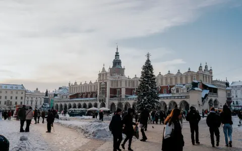Zimowy Rynek Główny w Krakowie z Sukiennicami i choinką. Spacer po Rynku to jedne z darmowych atrakcji Krakowa, nawet w śnieżny dzień.