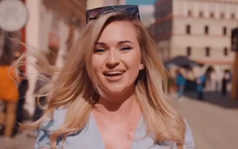 Uśmiechnięta blondynka w okularach na głowie, idealna do piosenki na 50 urodziny disco polo.