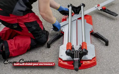 Un ouvrier en pantalon rouge utilise un coupe-carreaux professionnel pour ses travaux.