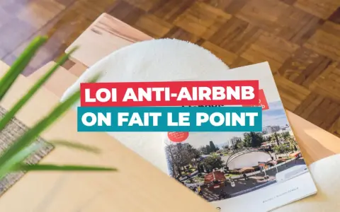 Un magazine sur la **loi Airbnb** est posé sur un meuble en bois. Le titre "Loi anti-Airbnb, on fait le point" est bien visible.
