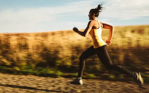 Kvinna springer i full fart, ett intensivt hiit pass utomhus.