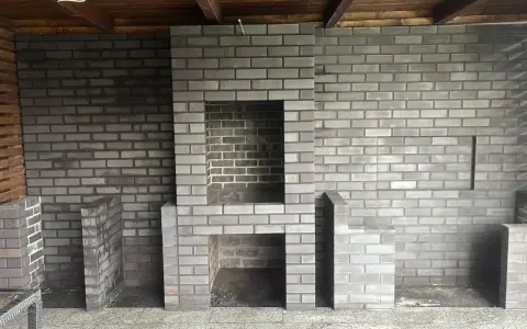 Nowy grill murowany z cegły projekt. Solidna konstrukcja z miejscem na palenisko i dodatkowymi półkami.
