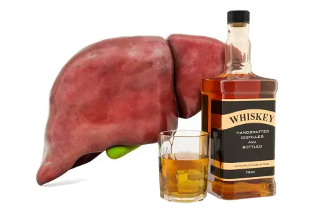 Wątroba obok butelki whiskey i szklanki z alkoholem symbolizuje negatywne skutki nadmiernego spożycia alkoholu, czyli spalanie alkoholu.