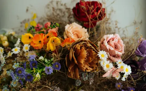 Un ramo de flores secas y artificiales, con tonos ocres, rosas, naranjas y morados. Una guía visual sobre como preservar flores para un recuerdo eterno.