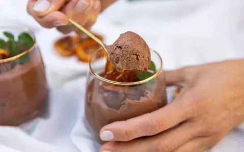 Delicioso mousse de chocolate, perfecto para los postres de Nochevieja. Una cucharada dorada revela su textura aireada.