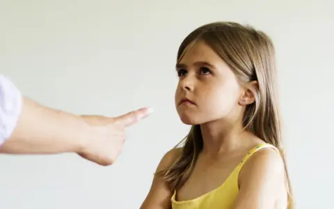 Zmarszczona buzia dziewczynki, gdy dorosły wskazuje palcem. Czasem potrzebny psycholog dla 3 latka, by zrozumieć emocje.