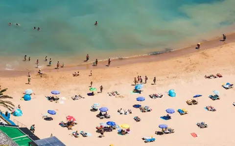 Sonnige Strände auf Madeira, Menschen genießen das Meer und den Sand. Ein entspannter Tag am Strand, vielleicht auch FKK-Bereiche, wie sie auf Madeira üblich sind.