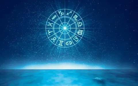 Jasny krąg zodiaku na tle nocnego nieba nad spokojnym morzem. Wodne znaki zodiaku wirują w kosmicznym tańcu.