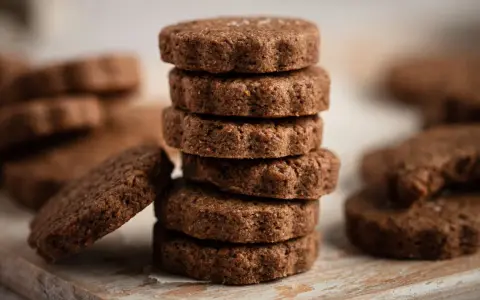 Stack of chocolate biscotti on a wooden board.