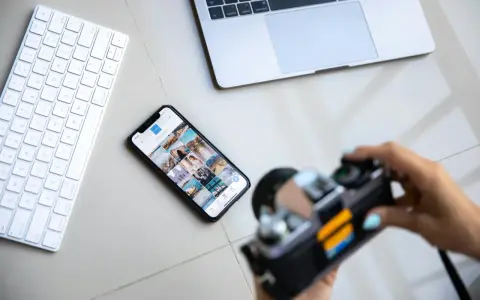 Aparat fotograficzny służy do uwieczniania chwil. Obok klawiatury, telefonu z Instagramem i laptopa, jest gotowy do pracy.