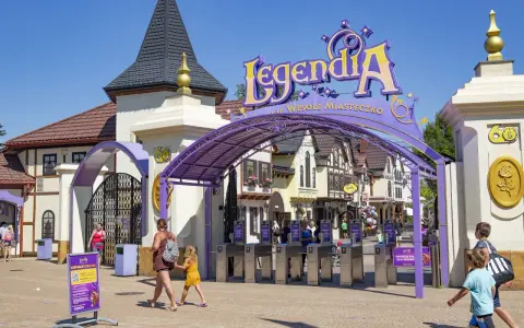 Wejście do Legendii, jednego z najpopularniejszych parków rozrywki w Polsce. Rodziny wchodzą przez bramki.