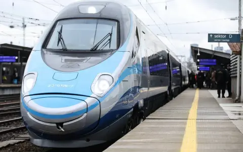 Nowoczesny, niebiesko-szary pociąg Pendolino stoi na peronie.