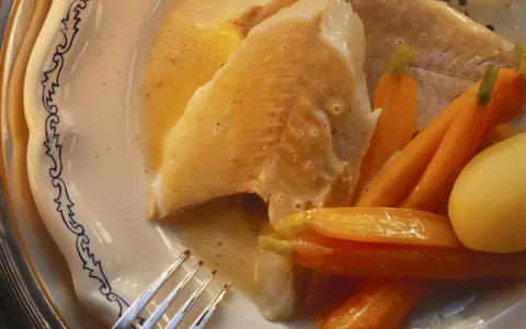 Zart gebratener Hecht mit Karotten und Kartoffeln, serviert in einer cremigen Sauce. Ein köstliches Gericht, das zeigt, wie man Hecht zubereiten kann.