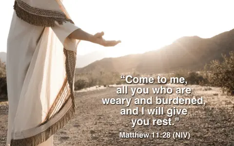 Jesus, in a flowing robe, extends an open hand in a desert landscape, offering rest as described in Matthew 11:28-30 meaning.