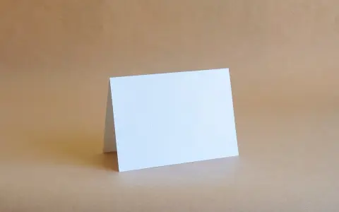 Biała kartka formatu B6 (12,5 x 17,6 cm) złożona na pół, gotowa na Twoje życzenia.
