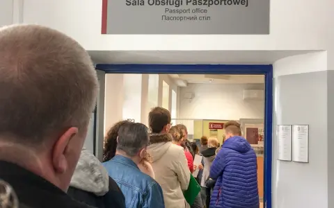 Kolejka do sali obsługi paszportowej. Czy odbiór paszportu musi być osobiście? Ludzie czekają w środku i na zewnątrz.