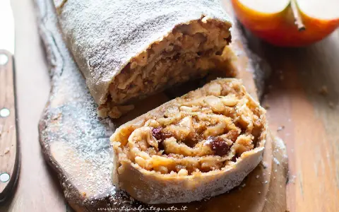 Un delizioso strudel di mele, cosparso di zucchero a velo, con un ripieno ricco di mele, uvetta e pinoli.