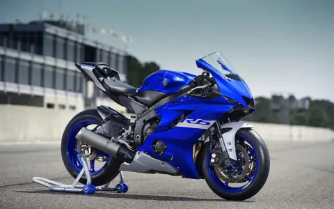 Niebieski motocykl sportowy Yamaha YZF R6 na torze wyścigowym, gotowy do akcji.