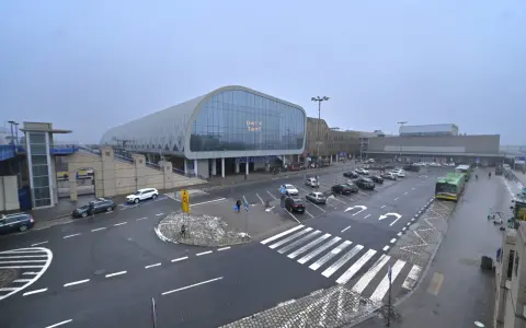 Dworzec Poznań Główny, z nowoczesną architekturą i parkingiem pełnym samochodów, gotowy na podróżnych do Nowego Tomyśla.