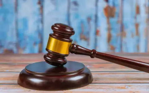Młotek sędziowski na drewnianym stole, symbolizujący ważną decyzję prawną, jak wniosek o pozbawienie władzy rodzicielskiej.