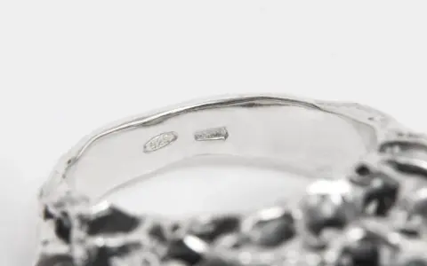 Anello in argento con incisione "925". Un numero argento e oro che brilla.