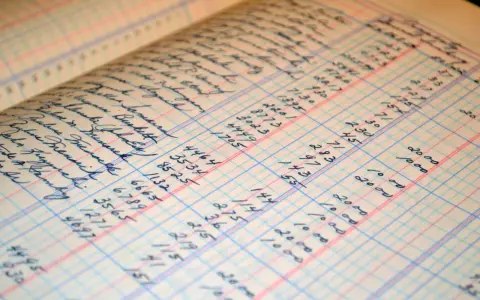 A close-up of a ledger book with handwritten entries, showing columns of names and numbers. This image illustrates the process of how to make a balance sheet, with detailed financial records.