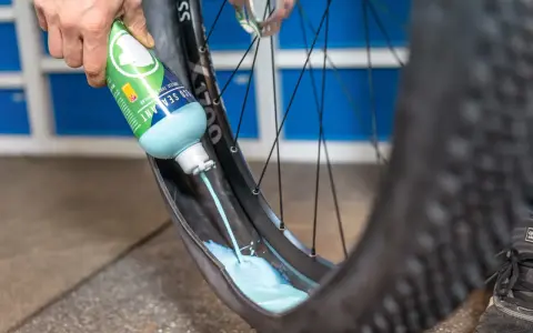 Flüssigkeit wird in einen MTB-Reifen gegossen, um ihn für den Tubeless-Betrieb vorzubereiten. Das ist ein wichtiger Schritt beim MTB Reifen wechseln.