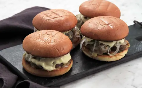 Fyra små burgare med fluffiga bröd och en generös mängd krämig big mac sås.