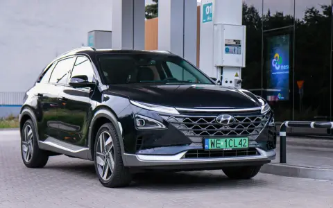 Czarny Hyundai Nexo, jeden z samochodów na wodór, tankuje na stacji.