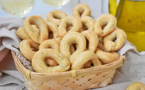 Koszyk pełen chrupiących taralli, idealnych do chrupania. Ten przepis na taralli to sekret włoskiej przekąski.