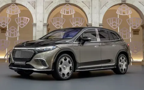Elegancki Mercedes-Maybach EQS SUV w kolorze szaro-czarnym prezentuje się luksusowo na tle ozdobnych arkad z logo Maybach.