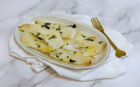 Delizioso merluzzo in friggitrice ad aria, croccante fuori e tenero dentro, guarnito con erbe aromatiche.