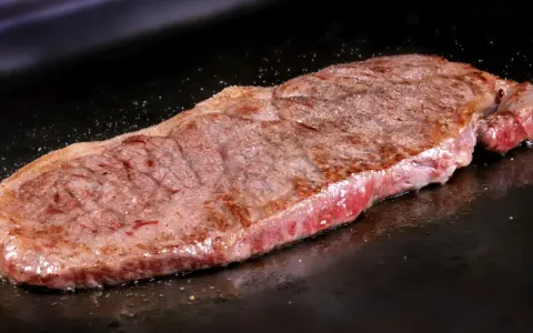 Filete de ternera jugoso cocinándose en una plancha. Perfecto para tus recetas con filetes de ternera.
