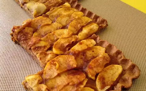 Dos porciones de tarta de manzana casera, con trozos de manzana dorados y espolvoreados con canela, sobre una base de masa crujiente.