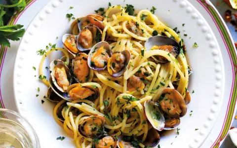 Spaghetti alle vongole surgelate, un piatto gustoso e veloce. Pasta dorata con molluschi freschi e prezzemolo tritato, pronto in pochi minuti.