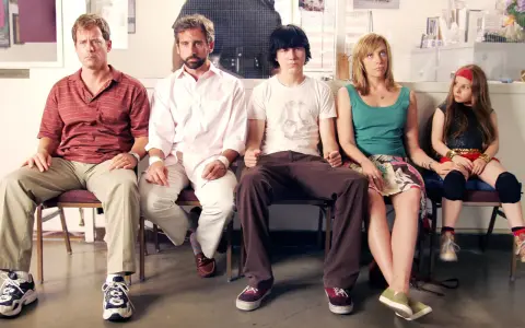 Un gruppo di persone, tra cui Steve Carell, siede in attesa, un momento iconico di film indipendenti famosi.